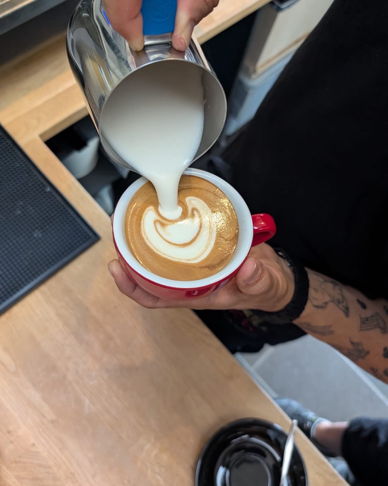 Barista gießt kunstvolle Latte Art bei LaRoc